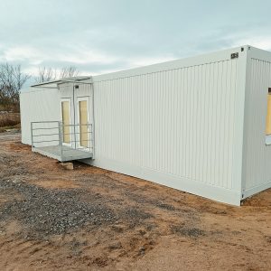 Aufnahme eines hellen Containergebäudes, das als Sozialunterkunft dient, von außen