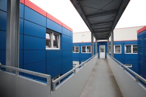 Blaues Containergebäude, das als Büro oder zur Verwaltung dient, fotografiert von außen