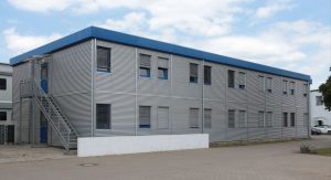 Aufnahme eines grauen Containergebäudes von außen
