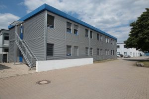 Aufnahme eines grauen Containergebäudes von außen