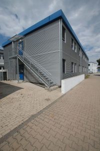 Aufnahme eines grauen Containergebäudes von außen