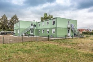 Aufnahme von einem grünen Containergebäude, das als Wohnunterkunft dient, von außen