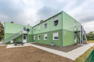 Aufnahme von einem grünen Containergebäude, das als Wohnunterkunft dient, von außen