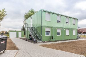 Aufnahme von einem grünen Containergebäude, das als Wohnunterkunft dient, von außen