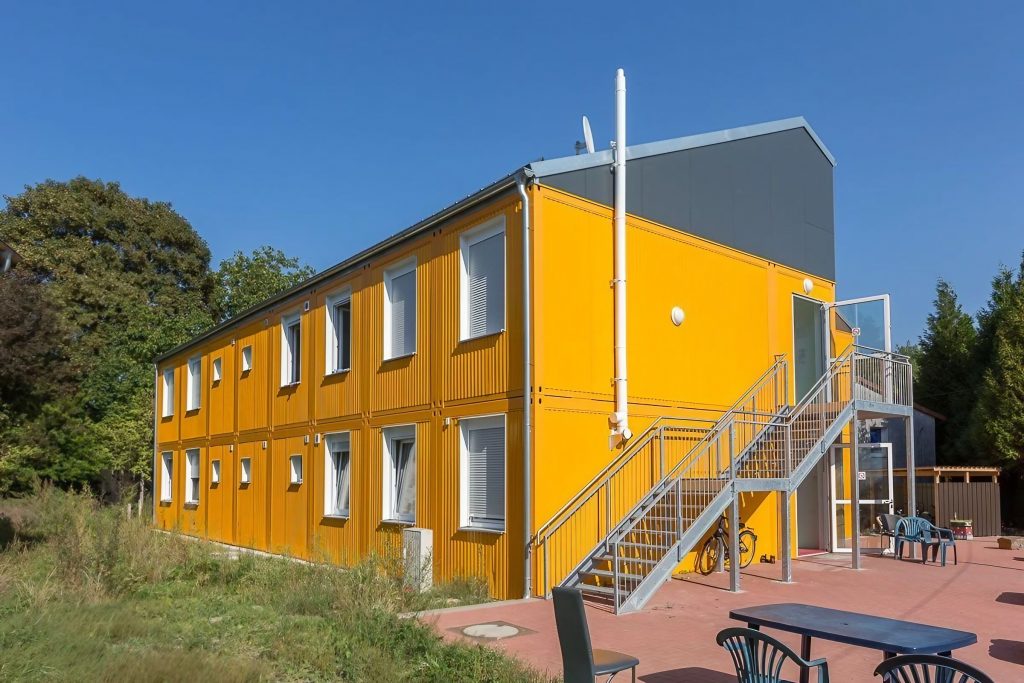 Gelbes Containergebäude, das als Wohnunterkunft dient von außen