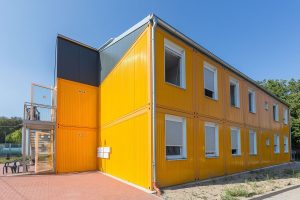Aufnahme von einem gelben Containergebäude, das als Wohnunterkunft dient, von außen