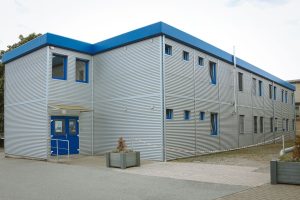Aufnahme eines grauen Containergebäudes von außen
