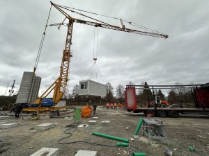 Containermodule für Geflüchtete werden angeliefert mit einem Baukran