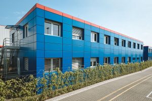 Blaues Containergebäude, das als Büro oder zur Verwaltung dient, fotografiert von außen