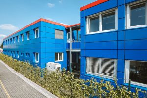 Blaues Containergebäude, das als Büro oder zur Verwaltung dient, fotografiert von außen