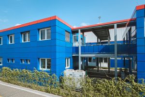 Blaues Containergebäude, das als Büro oder zur Verwaltung dient, fotografiert von außen