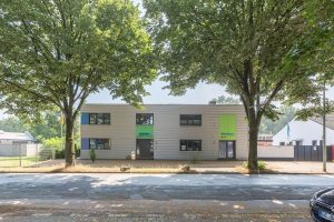 Graues Containergebäude, das als Büro oder zur Verwaltung dient, fotografiert von außen