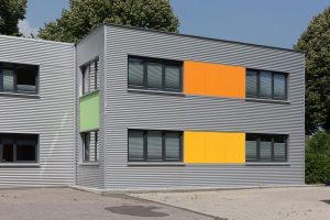 Graues Containergebäude, das als Büro oder zur Verwaltung dient, fotografiert von außen