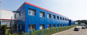 Blaues Containergebäude, das als Büro oder zur Verwaltung dient, fotografiert von außen