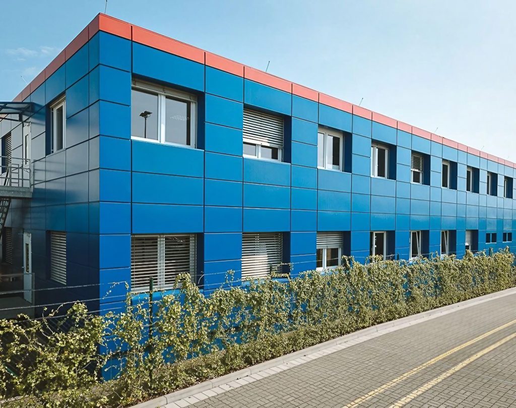 Blaues Containergebäude, das als Büro oder zur Verwaltung dient, fotografiert von außen