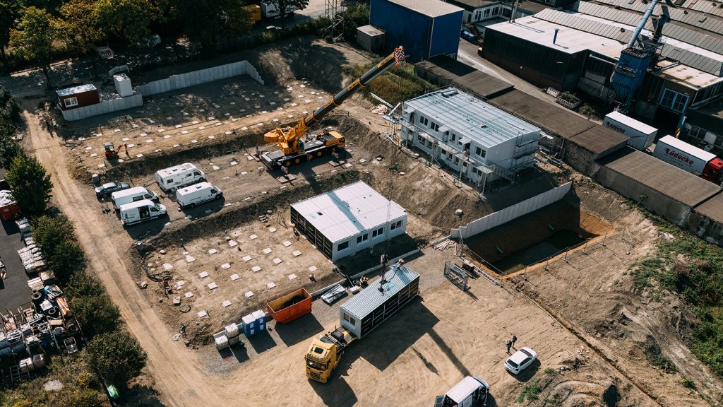 Drohnenaufnahme mit Ansicht der Baustelle eines Containergebäudes, welches als Flüchtlingsheim verwendet werden soll