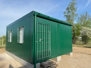 Außenansicht eines grünen Containergebäudes, welches als Aufenthalts- und Materialraum genutzt wird
