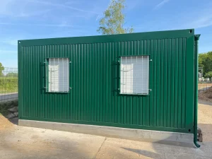 Außenansicht eines grünen Containergebäudes, welches als Aufenthalts- und Materialraum genutzt wird