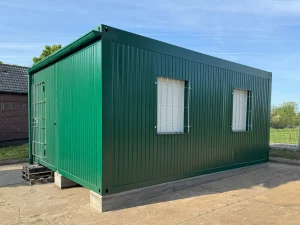 Außenansicht eines grünen Containergebäudes, welches als Aufenthalts- und Materialraum genutzt wird